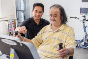 A physical therapist and a elderly man resident at the Canyon Springs rehab gym