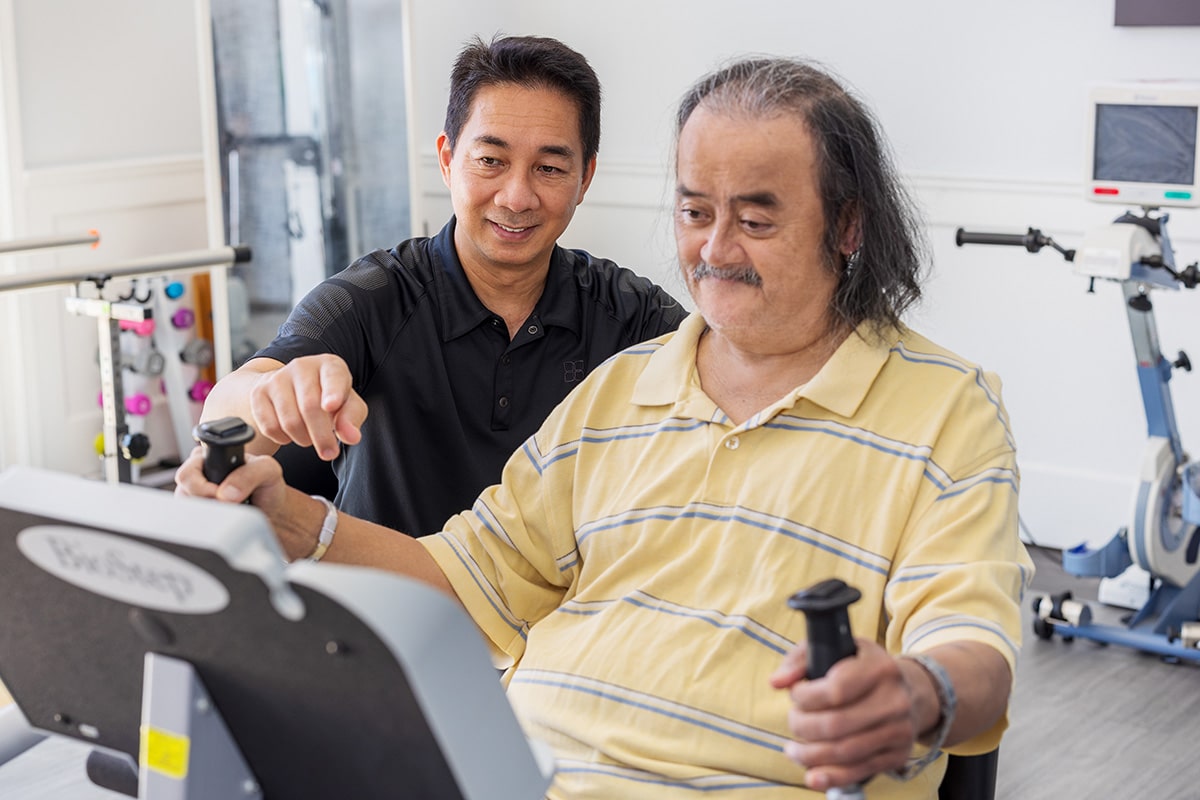 A physical therapist and a elderly man resident at the Canyon Springs rehab gym