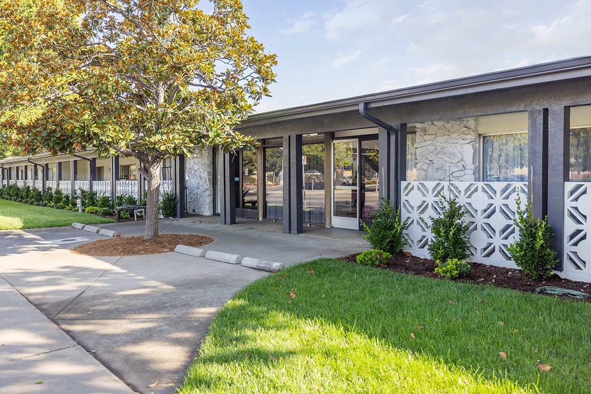 The front of the Canyon Springs facility with green grass and flowers
