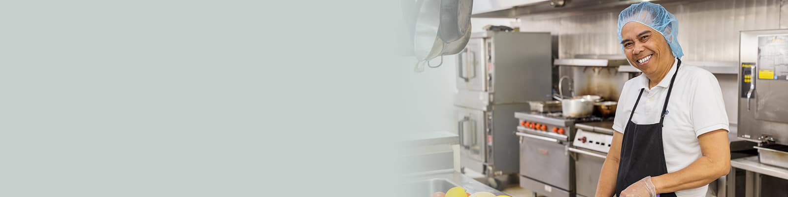A Kitchen staff member cutting vegetables