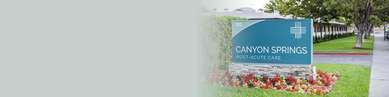 The front of the Canyon Springs facility with a monument sign and flowers